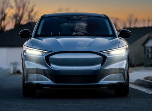 A front view of a modern electric vehicle at sunset.