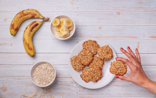 A top view of oatmeal banana cookies and ingredients on a wooden table