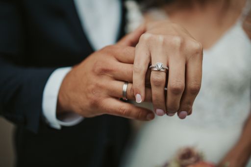 A beautiful shot of the hands of a bride and groom showing their rings - wedding, anniversary