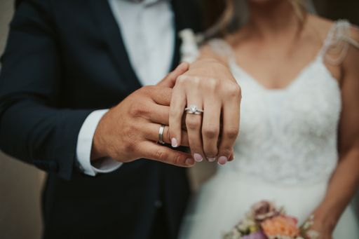 A beautiful shot of the hands of a bride and groom showing their rings - wedding, anniversary