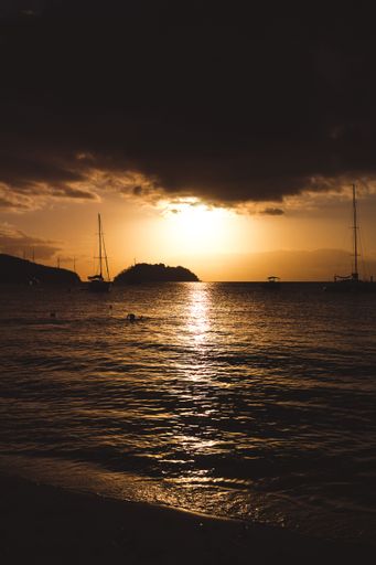 A vertical shot of a dramatic sunset over the sea in the horizon