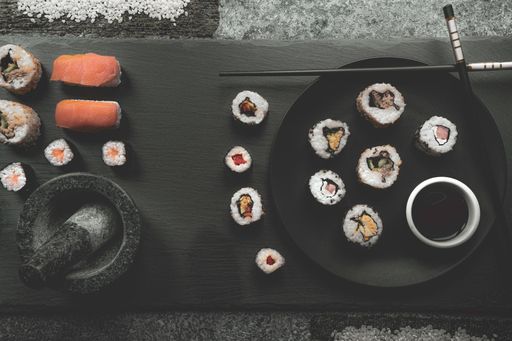 A top view of sushi rolls and nigiri on the black wooden board