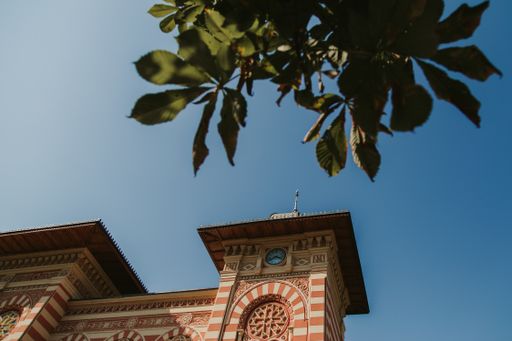 A low angle shot of a mansion facade against the blue sky