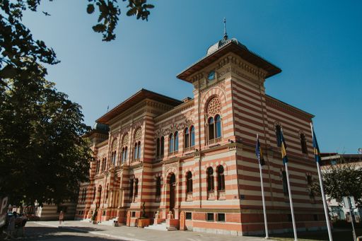A low angle shot of a mansion facade against the blue sky
