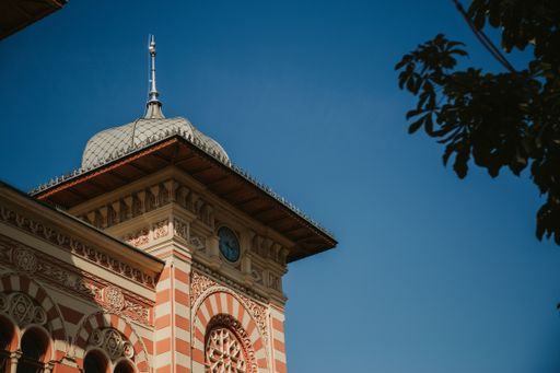 A low angle shot of a mansion facade against the blue sky