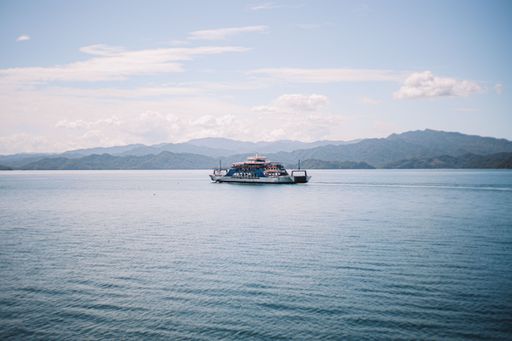 A sailboat navigating a crystal-clear blue body of water in Costa Rica