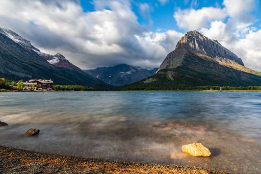 A long exposure shot of the Swiftcurrent lake with beautiful mountains  visible in the background