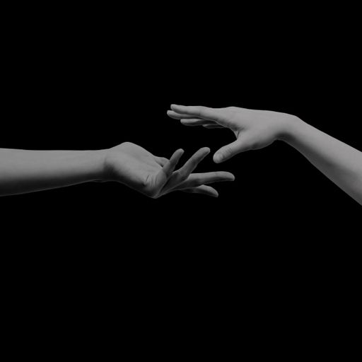 A scenic shot of hands trying to reach each other isolated on the black background