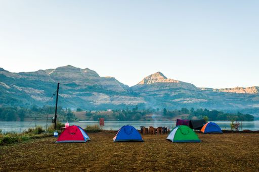 An areal shot of a beautiful landscape of camp and tents with hills in the background at Arthur Lake in India