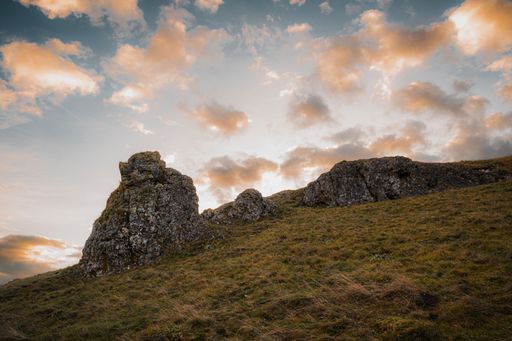A beautiful shot of a cloudy sunset sky over a rural hill with stone formations in Baden-Wurttemberg