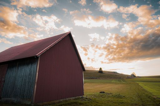 A beautiful shot of a cloudy sunset sky over a rural hill with a wooden barn in Baden-Wurttemberg