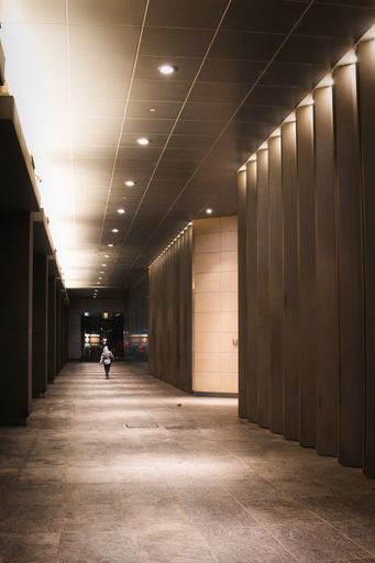 A woman walking through a long hallway at night
