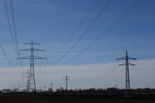 A low angle shot of power towers and lines on a cloudy day