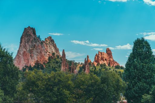 A beautiful shot of rock formations and green trees under the blue sky