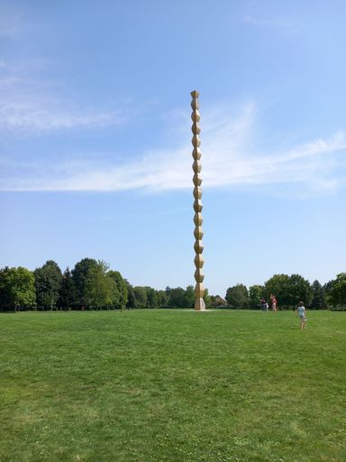 A vertical shot of Infinity Column monument against blue sky in a park in Romania