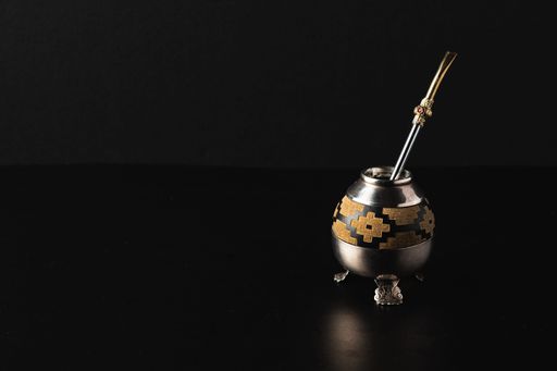 A closeup of Argentinian matero and bombilla in black background