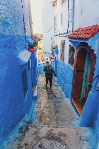 A vertical shot of the caucasian white female from behind enjoying the traditional blue architecture