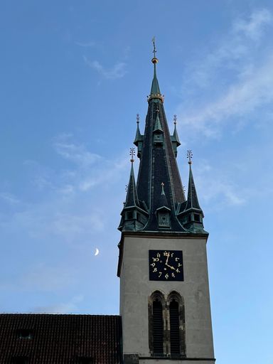 A vertical low angle shot of the clock tower of the St. Stephen's Church, in Prague