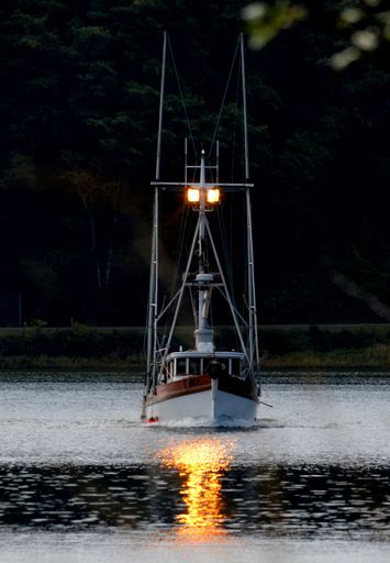 A vertical of a fishing boat sailing on the bay near Long Beach, Washington