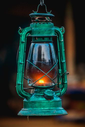A closeup shot of a green kerosene lamp on the blurred background