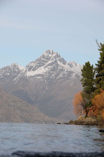 A vertical shot of a mountain range on the coast of an ocean on a sunny day