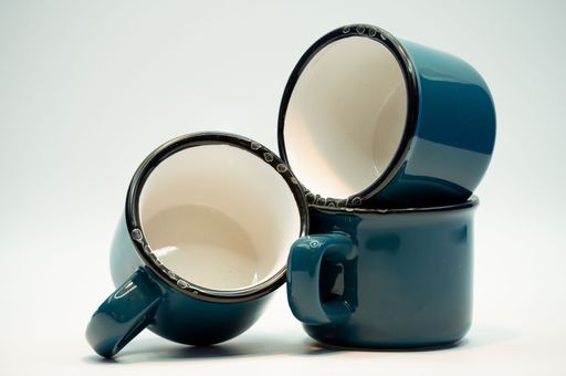 Three blue ceramic glazed cups isolated on a white background