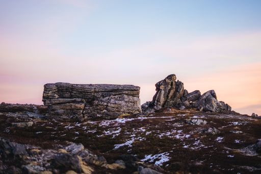 The rocky mountains covered with snow during scenic pink sunset, Tromso, Norway