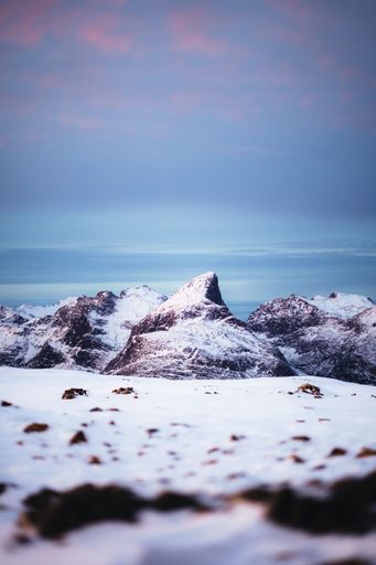 The rocky mountains covered with snow and blue sky, Tromso, Norway