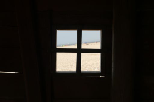 The silhouette of a square-shaped window in a building with a beach view