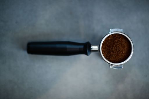 A close-up view of a portafilter with ground coffee for the coffee machine