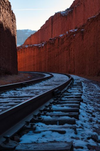A vertical shot of a long railway through the hills