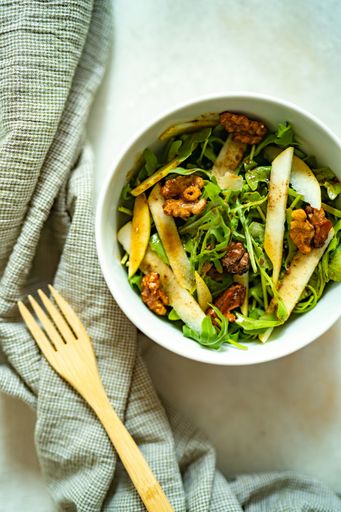 A vertical of a healthy and delicious vegan meal of walnut and fresh pear salad