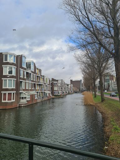 A beautiful view from a bridge to a river with Woning Boogjes buildings, Germany, vertical shot