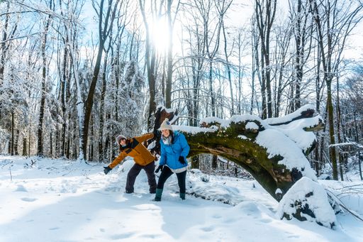 Two hiker friends having fun in a snowy forest of the Artikutza natural park in San Sebastian, Basque Country, Spain