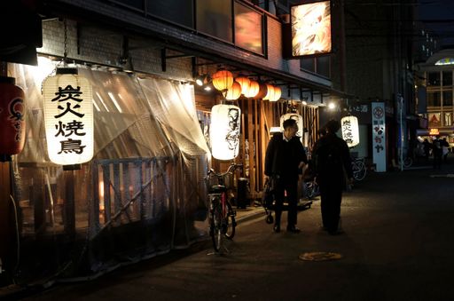 Tokyo, Japan - 3 January, 2023: Three people meet in front of a restaurant in the late evening hours in Tokyo, Japan.