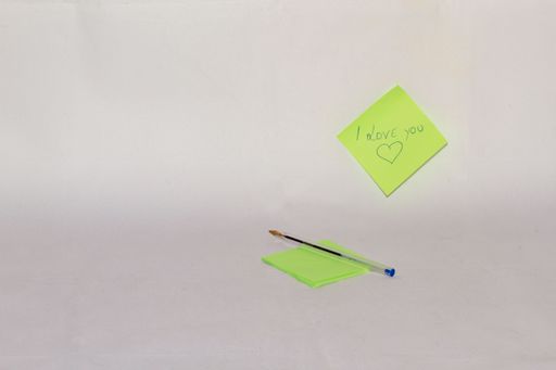 Note in which I love you is written by a lover on a small green sheet of paper with a blue pen.