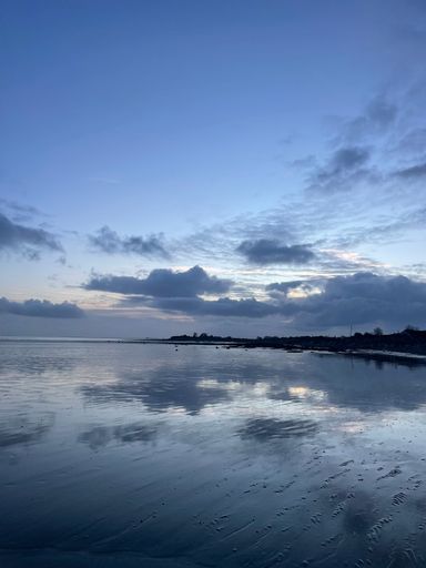 A vertical shot of a wet sandy beach of Morecambe Bay in Cumbria, England