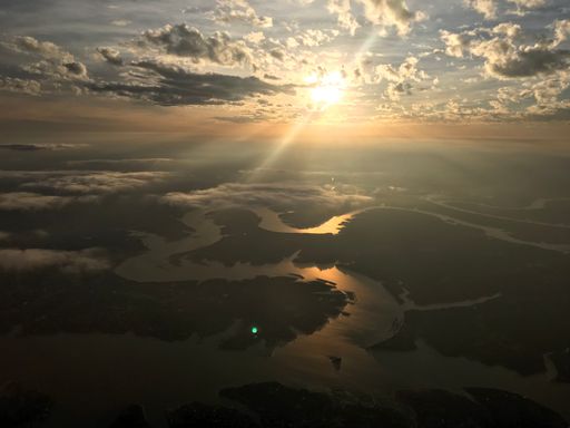 An aerial shot of a majestic sunset through the clouds over the river