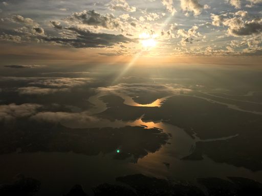 An aerial shot of a majestic sunset through the clouds over the river