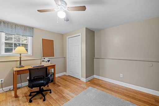 The interior of a modern suburban home office with a table and a rolling chair