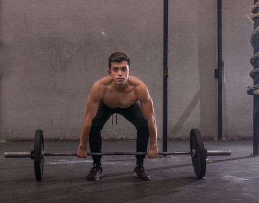 A closeup shot of an Athletic boy lifting weight at gym, fitness concept