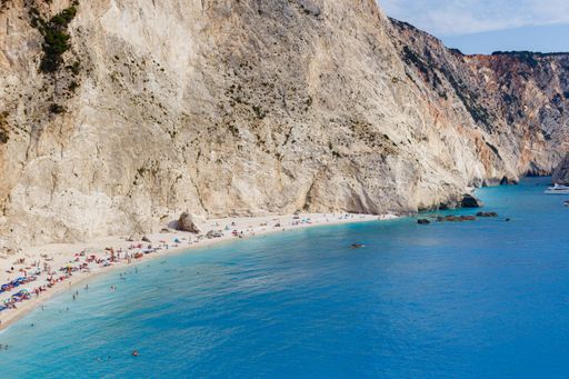 A high angle shot of people on the sandy beach and in the blue sea in Lefkada island, Greece