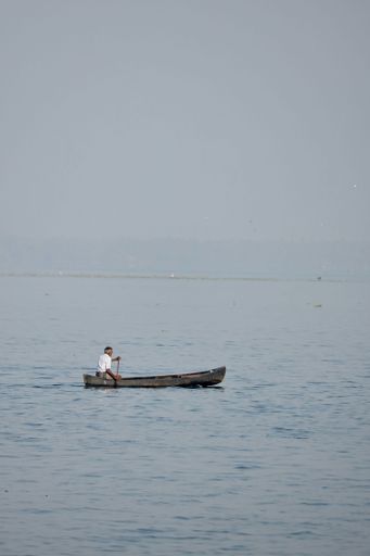Alappuzha or Alleppey, Kerala, India - January 1 2023: A selective focus of an unidentified south Indian fisherman in a canoe on the backwaters.