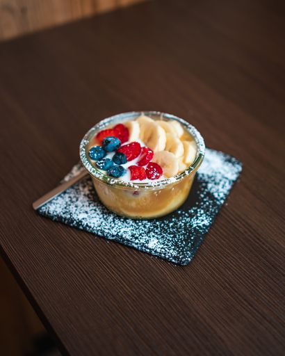 A closeup of a yogurt with banana and berries