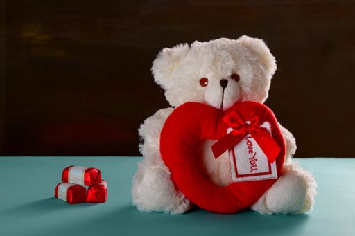 Teddy bear with love tag and chocolates to celebrate valentine's day
