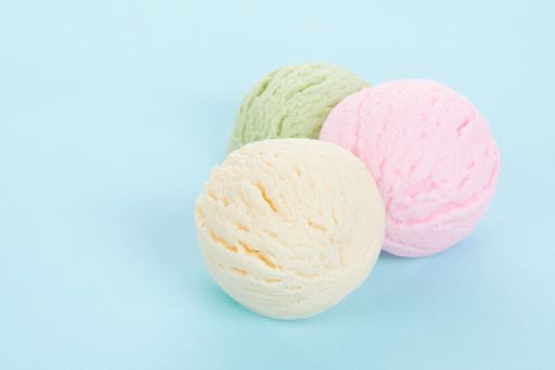 A closeup shot of various flavored delicious ice cream scoops isolated on blue background