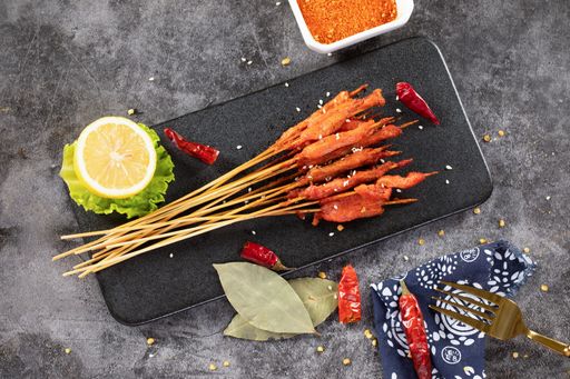 A top view of delicious meat on wooden skewers seasoned with various spices