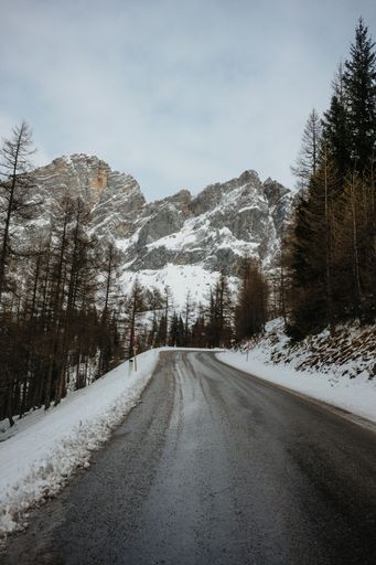 A winding mountain road with a blanket of snow covering the terrain