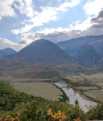 A vertical shot of a landscape with valleys and mountains seen on a sunny day