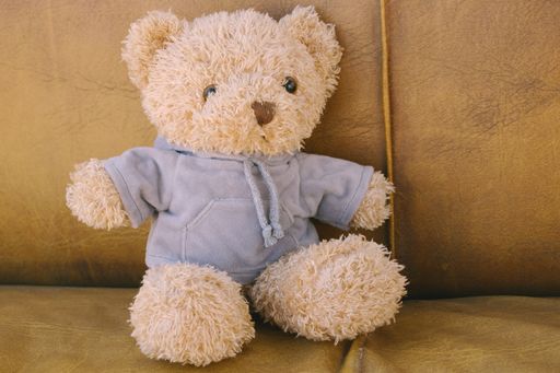 A closeup shot of a toy bear on a yellow sofa